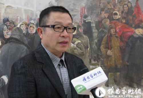 图为展览现场,四川美术学院院长罗中立接受雅昌艺术网记者的专访,背景