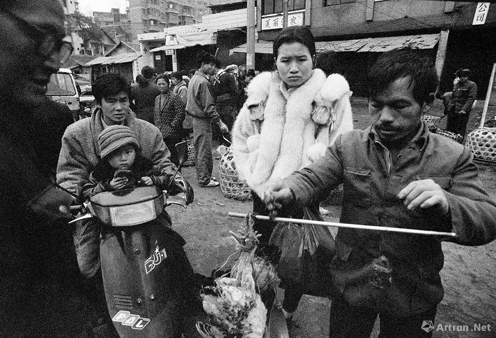 谢军作品：1993.1 贵州省 黔东南苗族侗族自治州 凯里市 穿着时髦貂皮的“万元户”在市场上购买活鸡滋补。