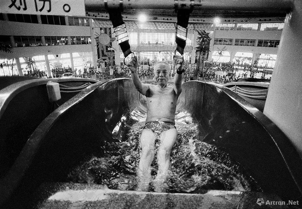 谢军作品：1994.7 沈河区  老者在当时号称亚洲最大的室内戏水场“夏宫”滑行冲浪。2009年夏宫被爆破拆除。